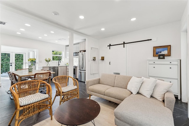 living area featuring french doors, visible vents, a barn door, and recessed lighting