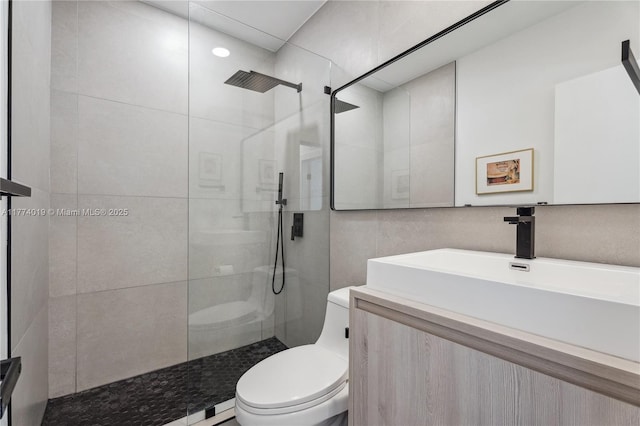 full bathroom with toilet, vanity, tile walls, and walk in shower