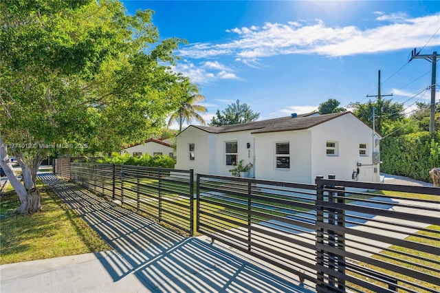 view of front of house featuring stucco siding and a fenced front yard