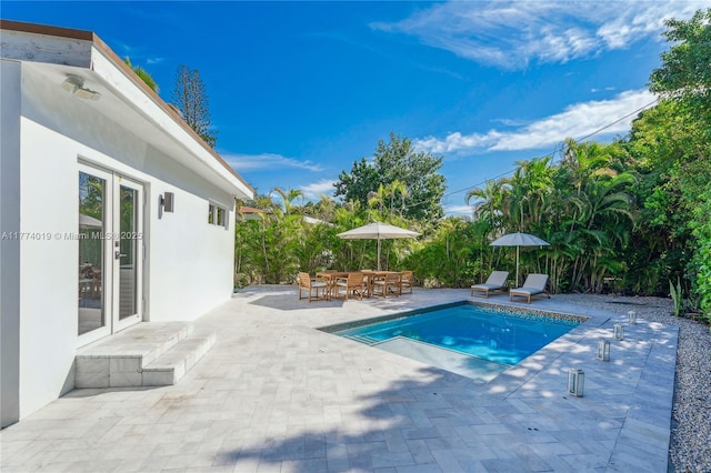 outdoor pool with outdoor dining area and a patio