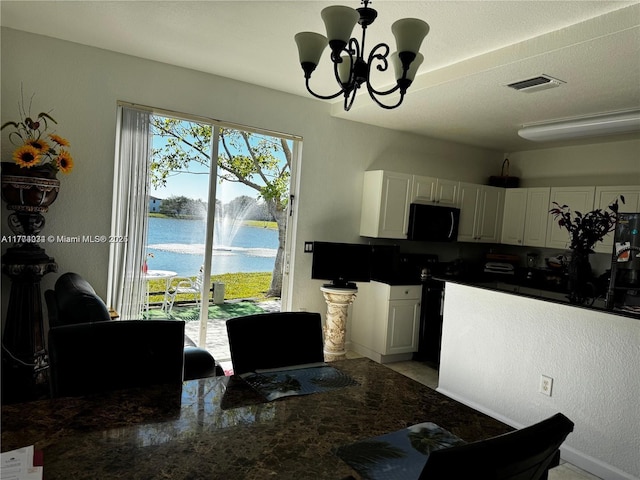kitchen featuring visible vents, a chandelier, black appliances, dark countertops, and white cabinets