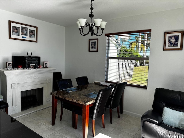 dining area with light tile patterned floors, a chandelier, a fireplace, and baseboards