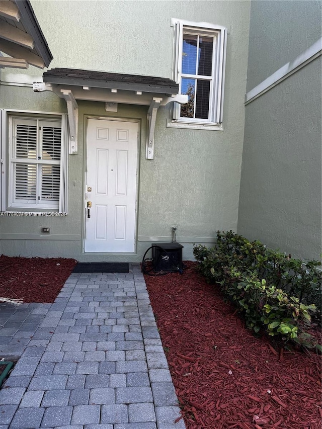 view of exterior entry with stucco siding