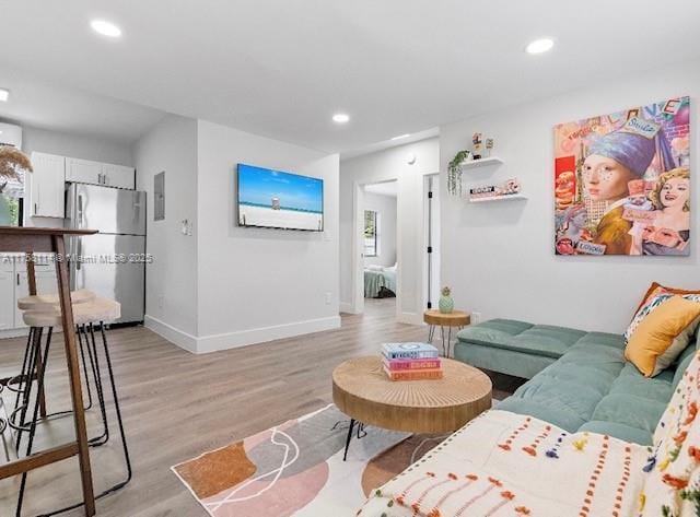 living room with baseboards, recessed lighting, and light wood-style floors