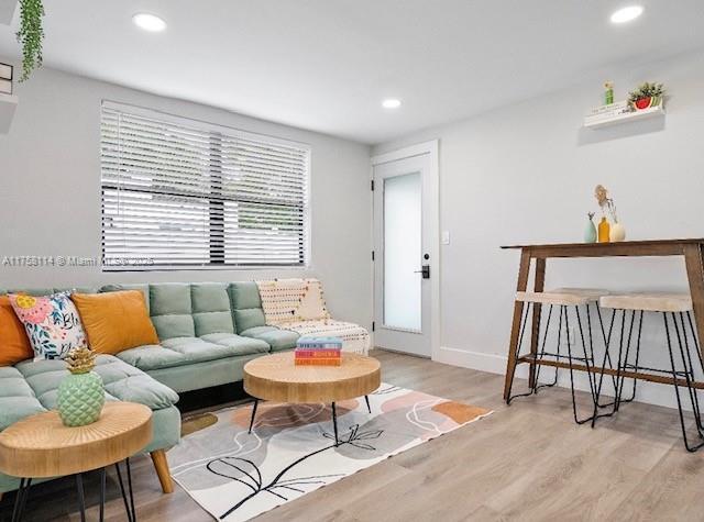 living room with baseboards, light wood-style floors, and recessed lighting