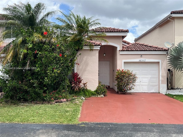 mediterranean / spanish home featuring driveway, stucco siding, a tiled roof, and a garage