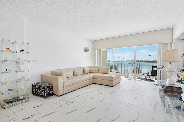 300 Bayview Dr Unit 308, Sunny Isles Beach, FL 33160 - living area with marble look tiles, a water view, and a textured ceiling