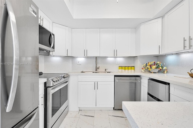 300 Bayview Dr Unit 308, Sunny Isles Beach, FL 33160 - kitchen featuring stainless steel appliances, white cabinetry, light marble finish floors, and backsplash