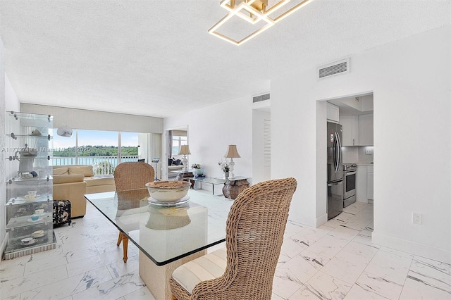 300 Bayview Dr Unit 308, Sunny Isles Beach, FL 33160 - dining room with light marble finish flooring and a textured ceiling