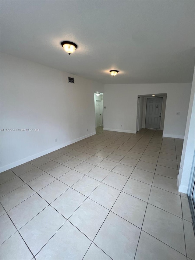 unfurnished room with baseboards, visible vents, and light tile patterned flooring