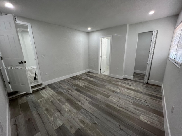 unfurnished bedroom with baseboards, wood finished floors, and recessed lighting