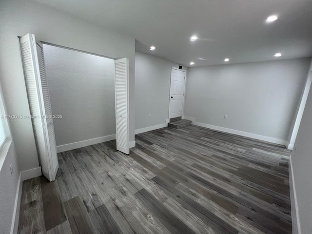 unfurnished bedroom featuring baseboards, a closet, wood finished floors, and recessed lighting