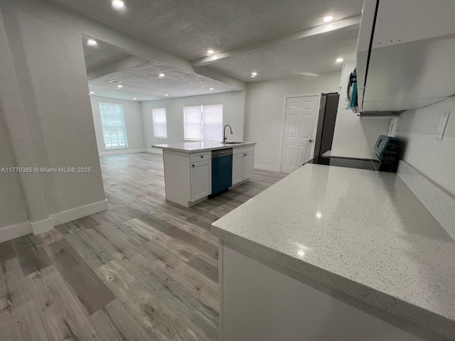 kitchen featuring light wood-style flooring, dishwasher, baseboards, white cabinetry, and stove