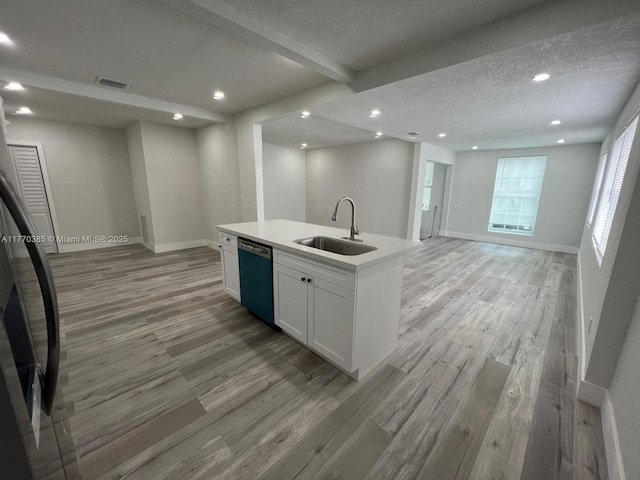 kitchen with dishwashing machine, visible vents, light wood-style floors, and a sink