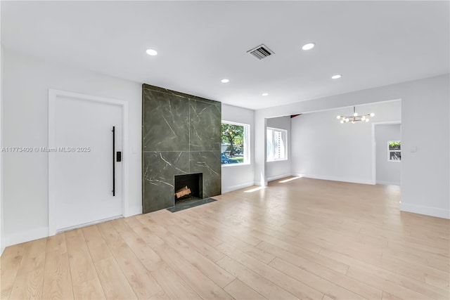 unfurnished living room with visible vents, wood finished floors, a chandelier, and recessed lighting