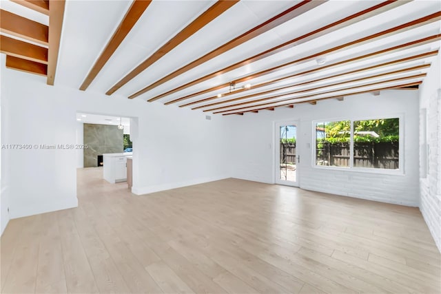 empty room featuring light wood-style floors and beam ceiling