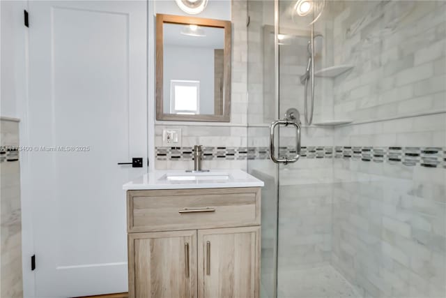 full bath featuring vanity and a shower stall