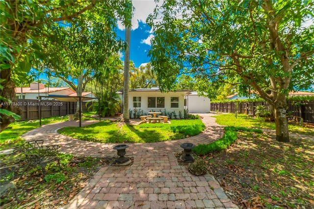 back of house with a lawn, a fenced backyard, and a patio area