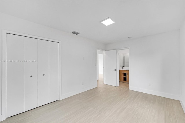 121 NW 35th St, Oakland Park, FL 33309 - unfurnished bedroom featuring ensuite bath, baseboards, a closet, and visible vents