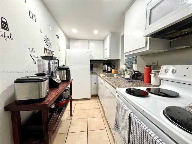 kitchen with light tile patterned flooring, white appliances, white cabinets, and a sink