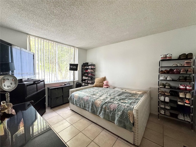 bedroom with a textured ceiling and light tile patterned floors