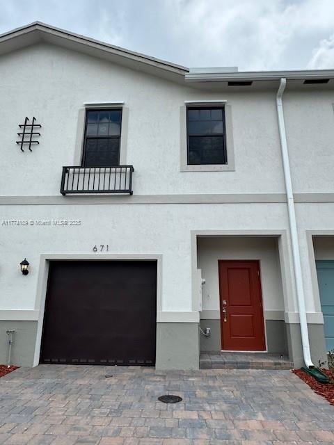 multi unit property featuring decorative driveway and stucco siding