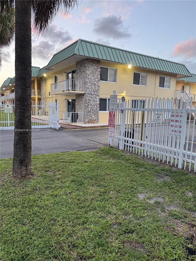 505 NW 177th St Unit 103, Miami Gardens, FL 33169 - exterior space featuring a front yard, a standing seam roof, stucco siding, fence, and metal roof