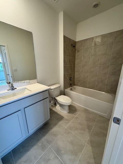 bathroom featuring tile patterned floors, vanity, toilet, and tub / shower combination
