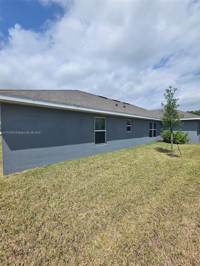 5317 Lugo St, Fort Pierce, FL 34951 - back of house featuring stucco siding and a yard