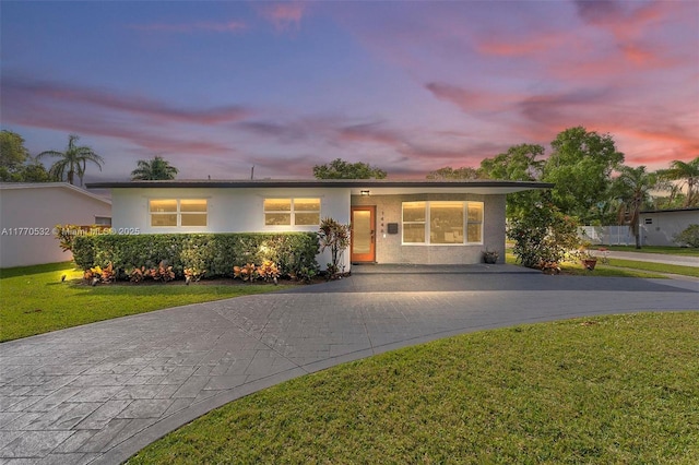 1446 Scott St, Hollywood, FL 33020 - view of front of house featuring a lawn, driveway, and stucco siding