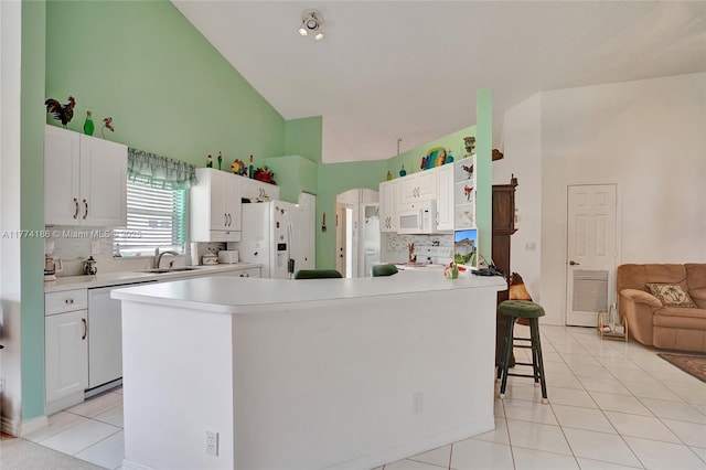 kitchen with tasteful backsplash, light tile patterned floors, white appliances, white cabinetry, and high vaulted ceiling