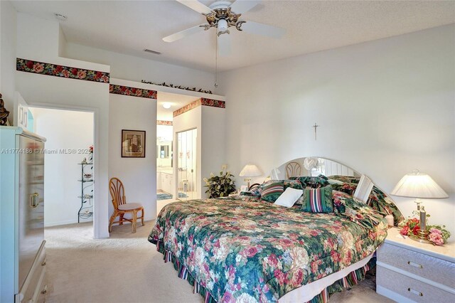 carpeted bedroom featuring ensuite bathroom, ceiling fan, and visible vents