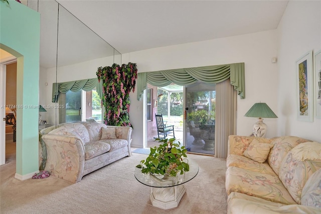 carpeted living room with arched walkways