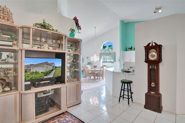 interior space with light tile patterned floors, an inviting chandelier, and lofted ceiling