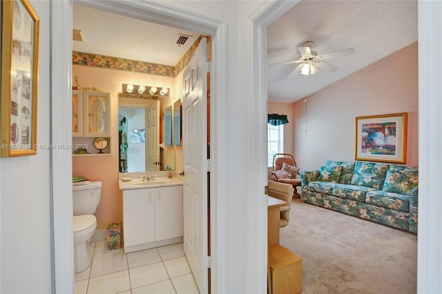 bathroom featuring vanity, toilet, visible vents, lofted ceiling, and ceiling fan