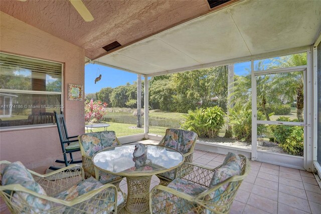 sunroom with a healthy amount of sunlight, ceiling fan, visible vents, and outdoor dining space