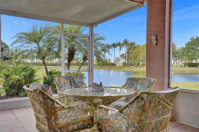 sunroom / solarium with a water view, a wealth of natural light, and outdoor dining space