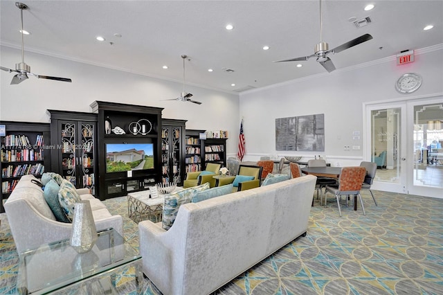 living area with visible vents, a ceiling fan, and ornamental molding