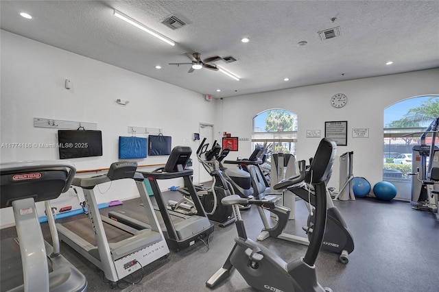 workout area featuring visible vents, a wealth of natural light, and a textured ceiling