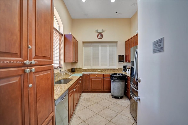 kitchen featuring light stone counters, a sink, a wealth of natural light, and stainless steel appliances
