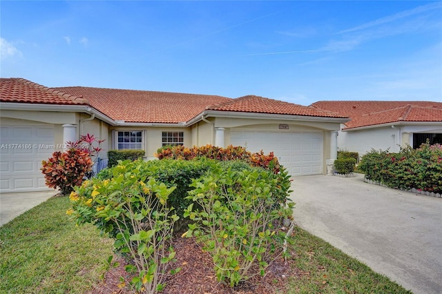 view of front of house with concrete driveway, stucco siding, a tiled roof, and an attached garage