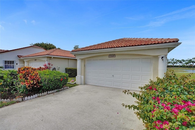 view of front of house with a water view, stucco siding, and a tiled roof