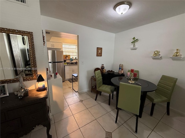dining room featuring a textured ceiling, visible vents, and light tile patterned floors