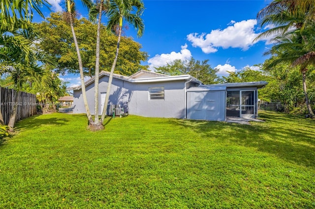 11390 NW 37th St, Coral Springs, FL 33065 - back of house featuring a fenced backyard, a sunroom, stucco siding, and a lawn