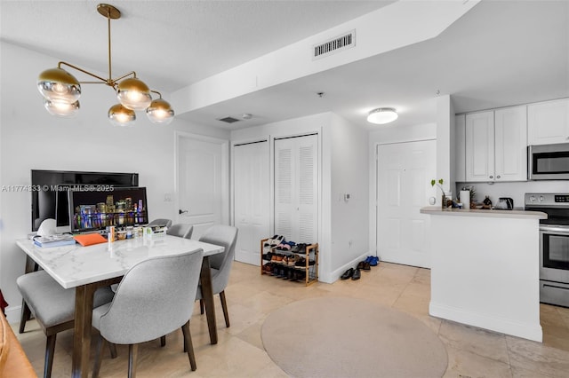 dining area featuring a chandelier, light tile patterned floors, and baseboards