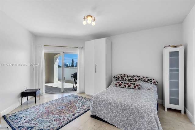 bedroom featuring access to exterior, light tile patterned floors, and baseboards