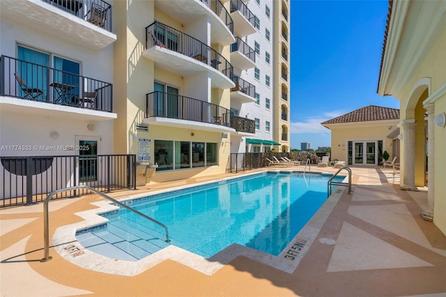 community pool featuring french doors and a patio area