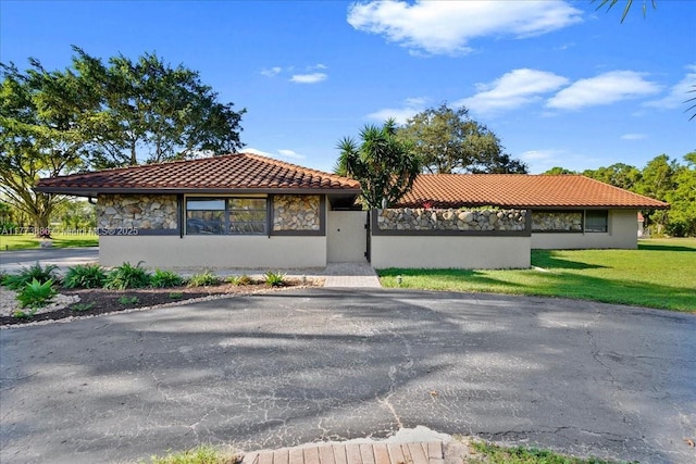 3761 Dellwood Blvd, Loxahatchee, FL 33470 - mediterranean / spanish house featuring a tiled roof, a front lawn, and stucco siding