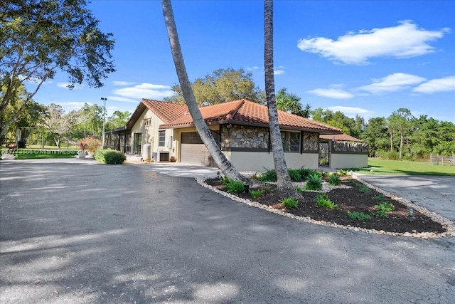 3761 Dellwood Blvd, Loxahatchee, FL 33470 - view of building exterior with a garage and asphalt driveway