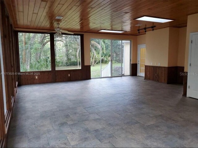 1950 S Tanner Rd, Orlando, FL 32820 - unfurnished room featuring stone tile flooring, wooden walls, wood ceiling, and a wainscoted wall